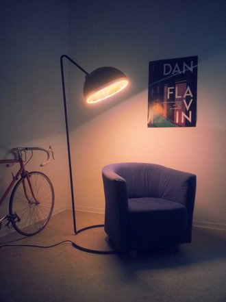 Fotografie der Lampe, die einen bequemen Sessel beleuchtet