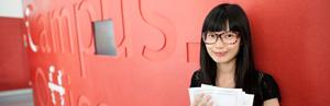 asiatische Studentin vor einer roten Wand