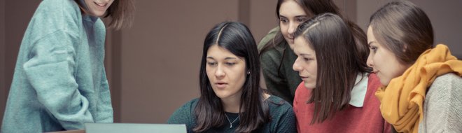 Studierende bei der Gruppenarbeit betrachten einen Laptop