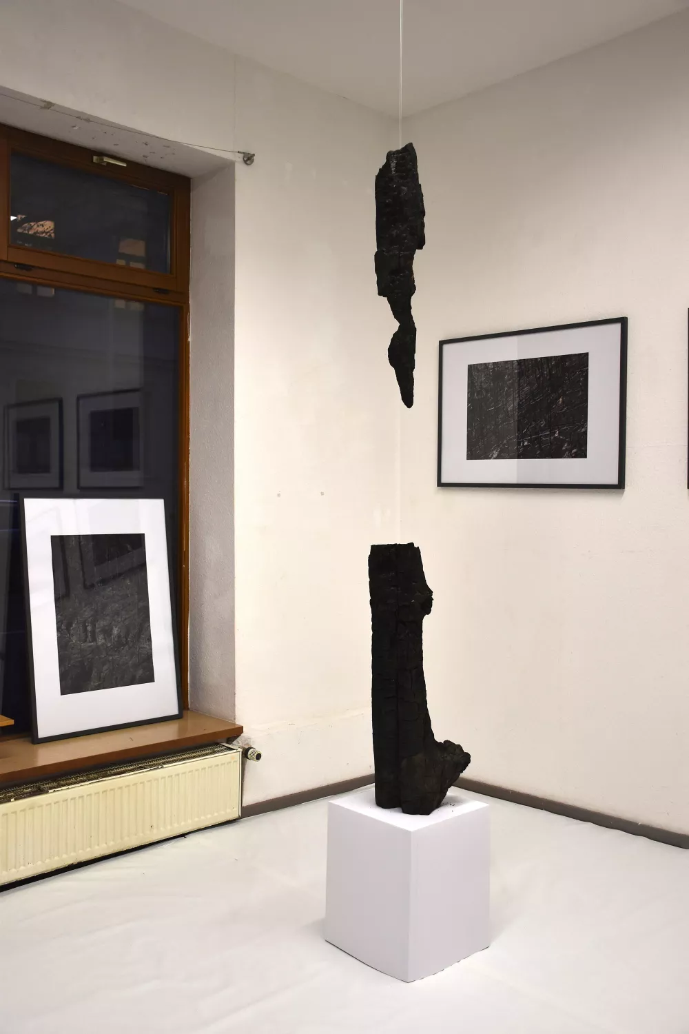 Ausstellungsaufbau, Bilderrahmen, verbranntes Holz abgehangen von der Decke
