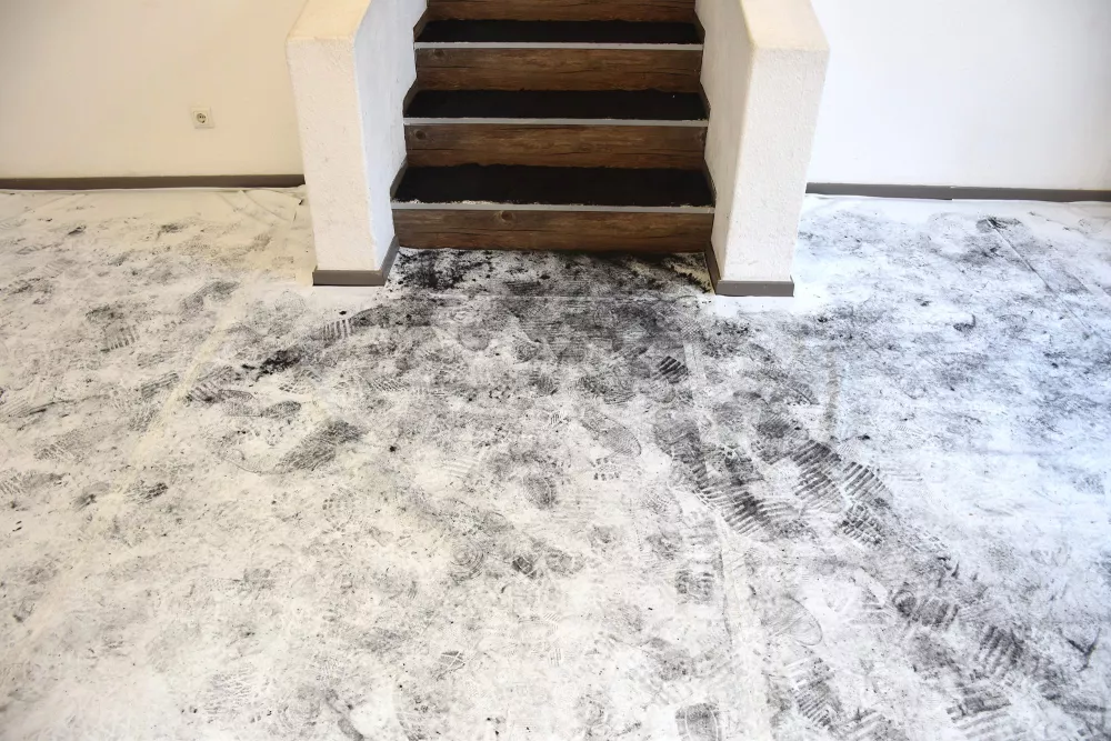 Boden mit Schuhabdrücken und schwarz-verstaubte Treppen