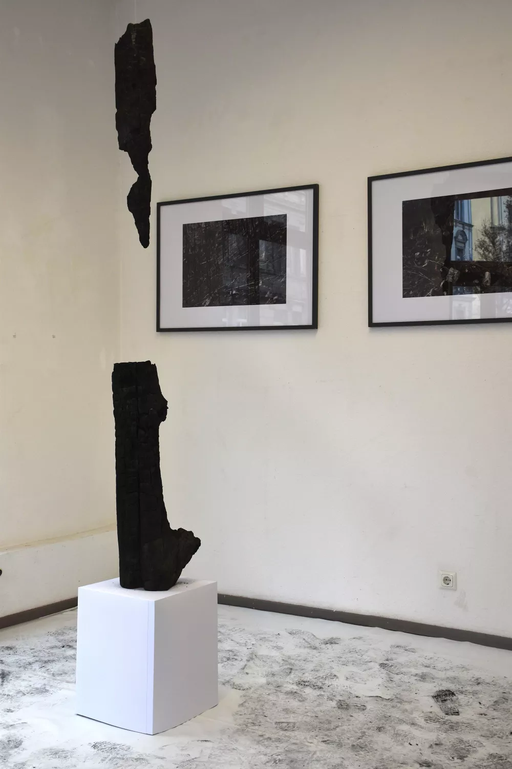 Ausstellungsaufbau, 2 Bilderrahmen, verbranntes Holz abgehangen von der Decke
