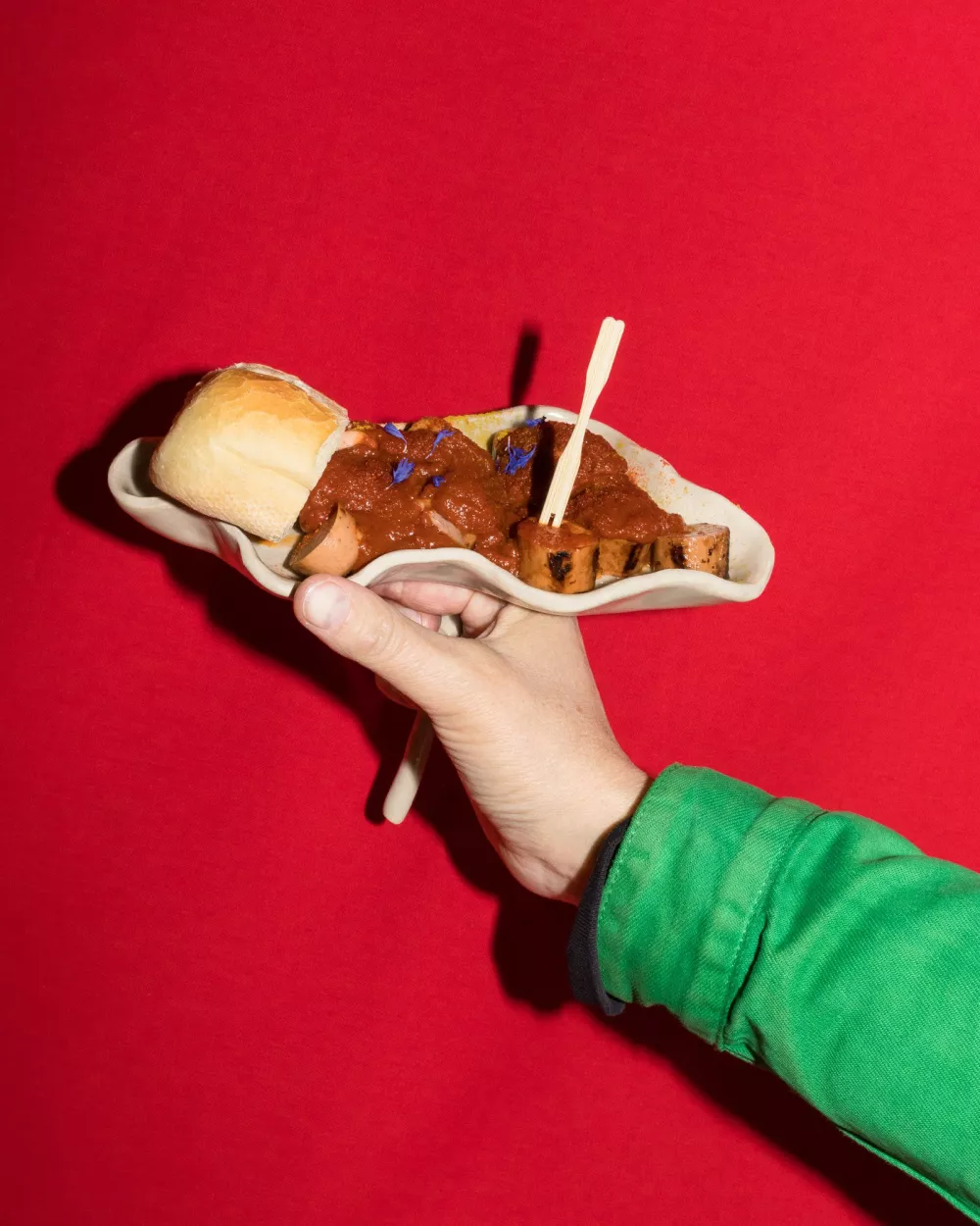 Currywurst, die von einer Hand gehalten wird
