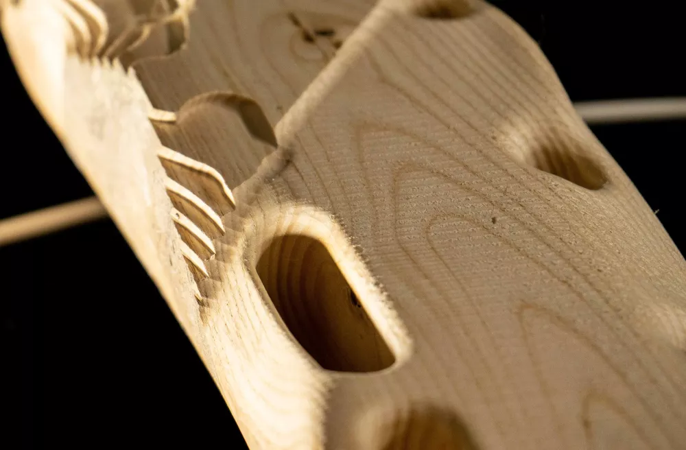 Nahaufnahme eines bearbeiteten Holzes mit gestufter Struktur und einigen kleinen Mulden