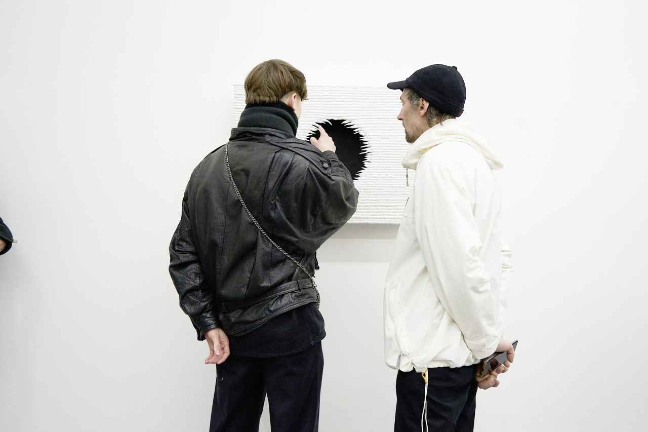 two visitor viewing art piece on a wall