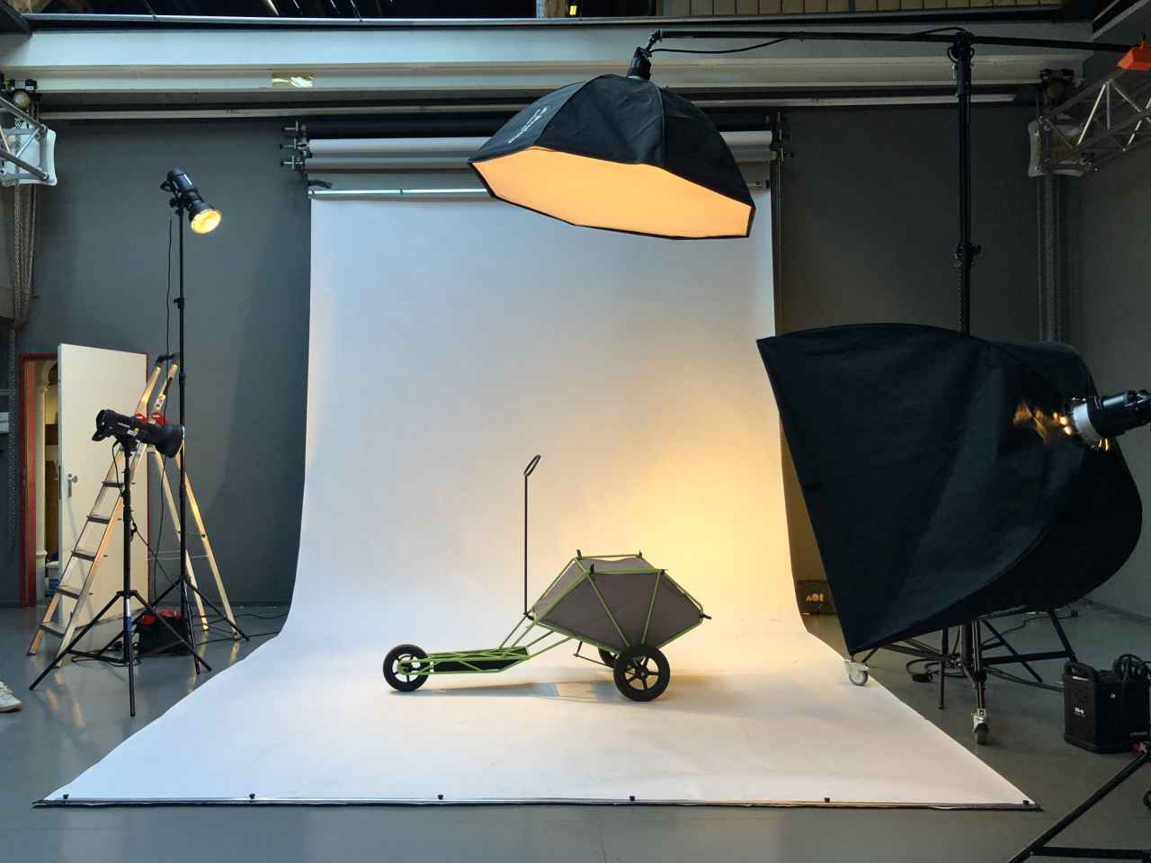 A three-wheeled cargo scooter during a photoshoot in a studio