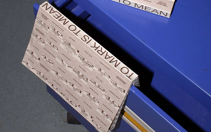 »To Mark is to Mean«: Several copies of the publication are displayed on a blue piece of furniture. The cover and spines feature typographic designs. Photo: Emelie Grannert