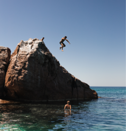 People jumping into a body of water