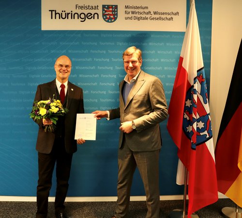 Wissenschaftsstaatssekretär Carsten Feller überreicht die Ernennungsurkunde an Dr. Horst Henrici. (Foto: TMWWDG)