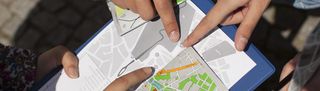 Picture of a map of Weimar. Several fingers are pointing on the map.