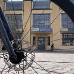 Main building photographed through the spokes of a bicycle