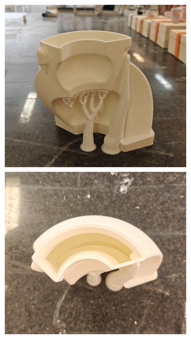 Ein 3D-gedrucktes Modell einer zweiteiligen Gießform steht auf einer Werkbank. Die obere Aufnahme zeigt die Außenansicht, die untere den Querschnitt.