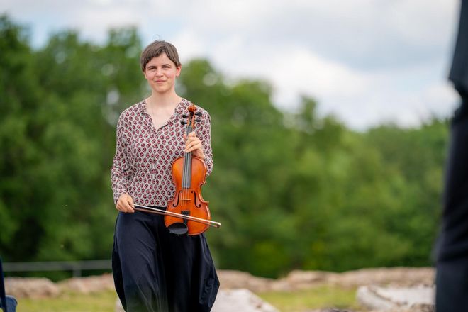 Musician Gesa Bartuschka holds her violin in her hand