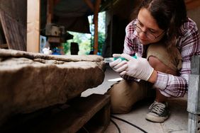 Copyright: Vogtlandpioniere Eine Restauratorin kniet vor einem Stein. Sie arbeitet im Projekt "preserve4future" der Initiative Vogtlandpioniere. Copyright: Vogtlandpioniere