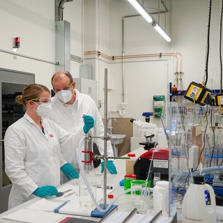 Prof. Dr. Silvio Beier examines wastewater samples in the laboratory with an employee of the Chair of Urban Bioengineering for Resource Recovery. (Photo: Dana Höftmann)
