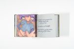 Open picture book with a colourful illustration on the left and handwritten text on the right. The illustration shows a figure with a round belly and blue clothing.