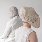 Zwei Personen, die Kopfbedeckungen mit elektrischer Verkabelung tragen