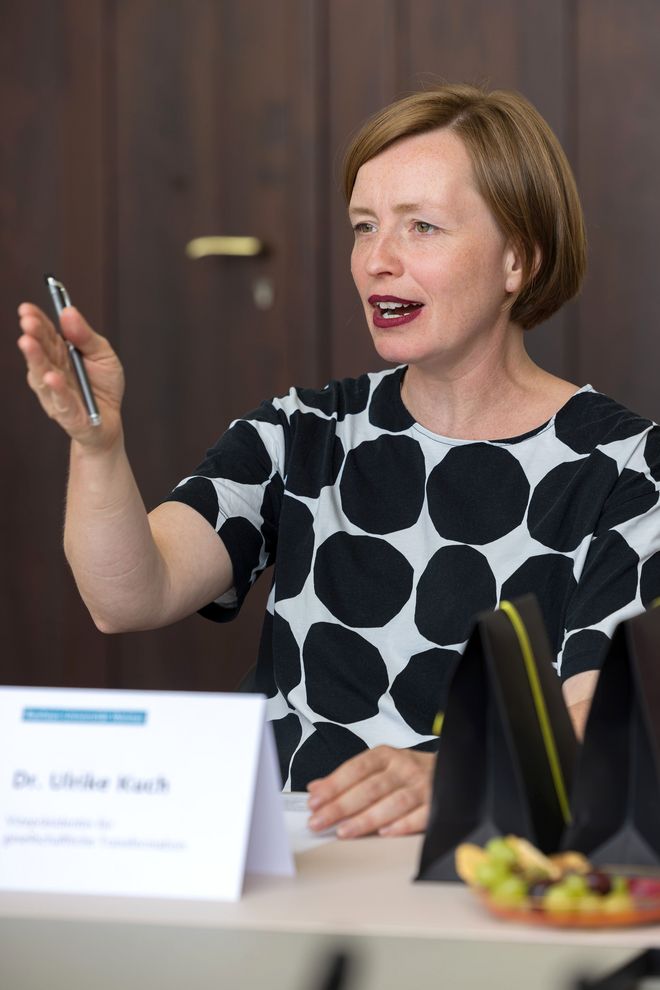 Vizepräsidentin Dr. Ulrike Kuch am Besprechungstisch: Sie spricht, sieht konzentriert, interessiert und bestimmt aus, sie gestikuliert mit ihrer Hand, in der sie einen Stift hält.