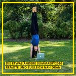 a woman does a handstand while looking at a laptop screen