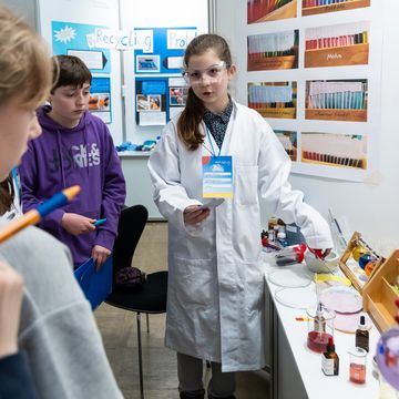 »Sauer-alkalisch-bunt: Auf der Suche nach einem Universalindikator«: Die Schülerin Anouk Fischer (Mitte) vom Goethegymnasium Weimar erklärte ihr Projekt interessierten Besucher*innen. Sie erhielt dafür den ersten Preis in der Sparte »Schüler experimentieren« im Bereich Chemie. Foto: Bauhaus-Universität Weimar/ Matthias Eckert