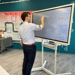 Mann steht an Whiteboard und fügt einer darauf befindlichen Mindmap etwas hinzu
