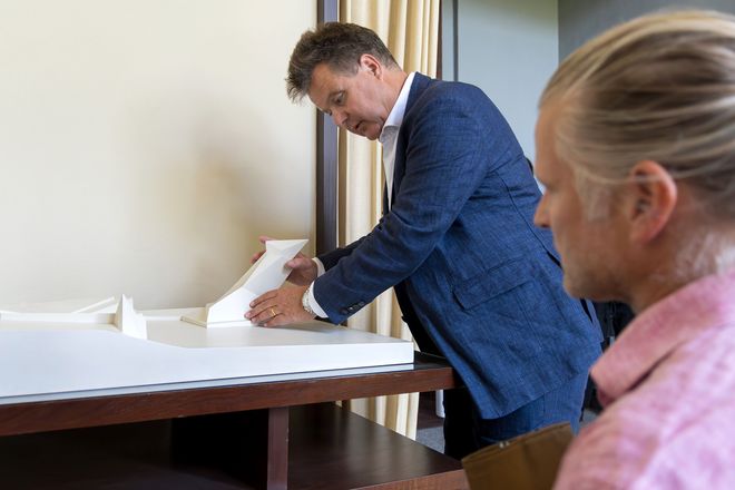 Jürgen Dusel betastet ein Modell von Walter Gropius, das im Gropiuszimmer steht. Es ist das Modell des Denkmals für die Märzgefallenen, das auf dem historischen Friedhof in Weimar steht. Vorne auf dem Foto ist Martin Ahners Kopf zu sehen, der ihm dabei zusieht.