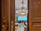 Durch eine leicht geöffnete Flügeltür ergibt sich ein Blick in einen Konferenzsaal