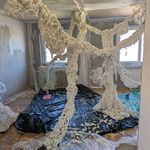 Room installation made of foam-like material branching through the space in an unfinished interior