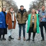 Drei Frauen und zwei Männer stehen auf der Straße und blicken in die Kamera
