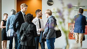 Menschen warten im Foyer auf den Beginn der Stipendienfeier