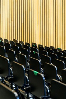 Photo of the empty "Audimax" lecture hall of the Bauhaus-Universität Weimar. Several backrests have been marked with a green dot to indicate to students where they can sit and still follow the physical distancing rules during the Corona-pandemic.