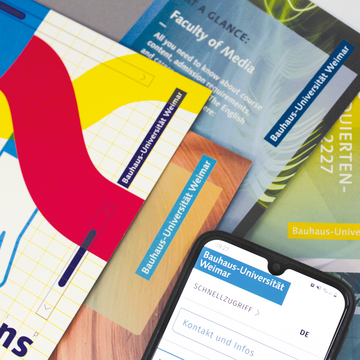 Eine Auswahl von verschiedenen Printbroschüren und ein Smartphone-Display. Foto: Universitätskommunikation / Samira Gebhardt