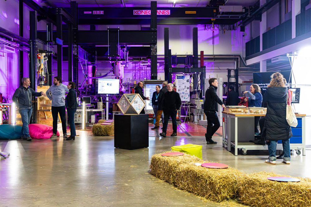 im lila beleuchteten Labor liegen Strohballen; Menschen laufen dazwischen umher