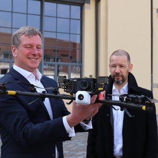 Prof. Dr. Guido Morgenthal (r.) demonstrierte dem Staatssekretär Carsten Feller (TMWWDG) mit einem Drohnenflug seine Forschung zu denkmalgerechter Sanierung historischer Bauwerke. (Foto: TMWWDG/C. Werner)