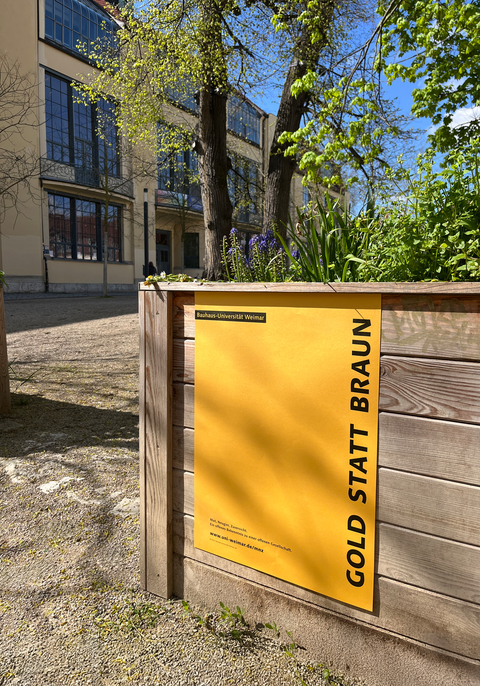 landesweiter Aktionstag: »Gold statt Braun – für ein weltoffenes Thüringen« »Gold statt Braun«-Plakat vor der M18 mit Blick auf das Hauptgebäude der Bauhaus-Universität Weimar