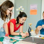 Drei Personen tüfteln an einem Projekt.