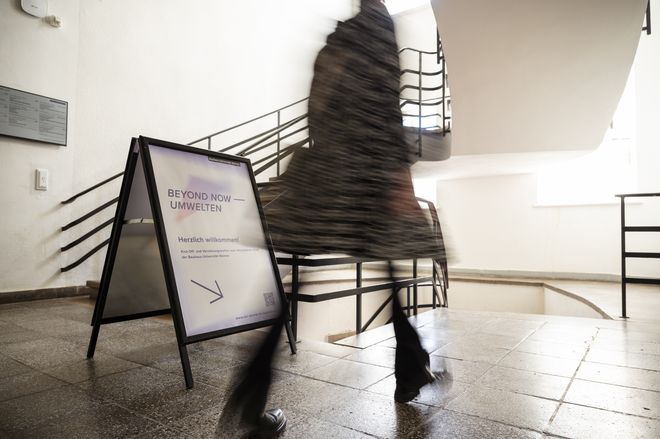 eine Person folgt dem Pfeil auf dem Aufsteller für die Auftaktveranstaltung