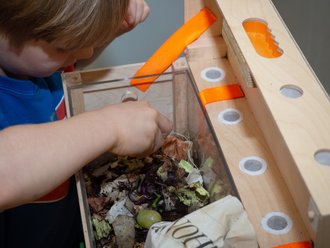 A child deals with organic waste with his hands.