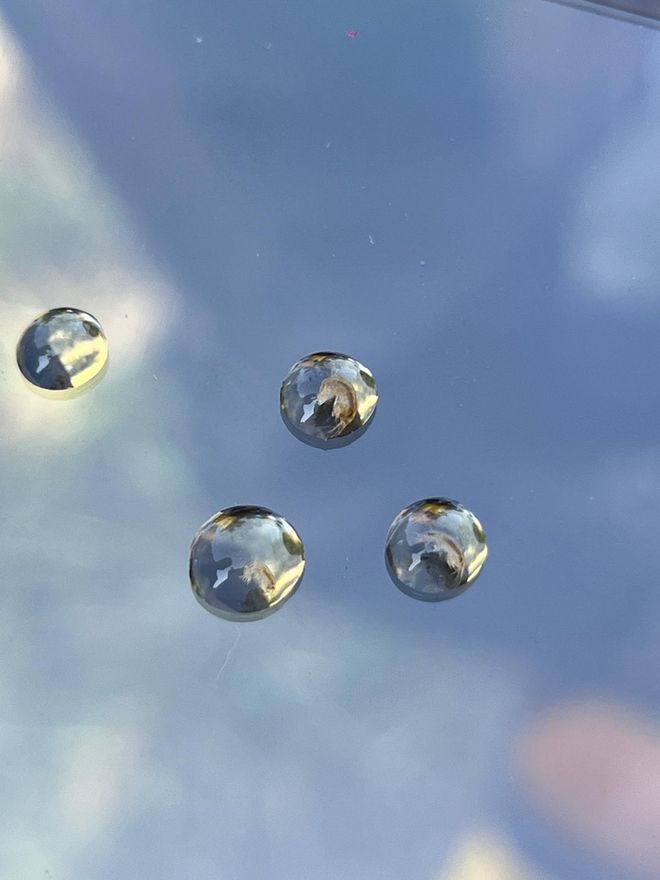 Metallkugeln schwimmen auf einer Wasseroberfläche