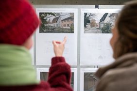 Zwei Personen sehen sich Architekturentwürfe an