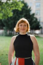 Porträt von Dr.-Ing. Chalett Wenig im Freien, vor unscharfem Hintergrund mit Bäumen und Gebäuden