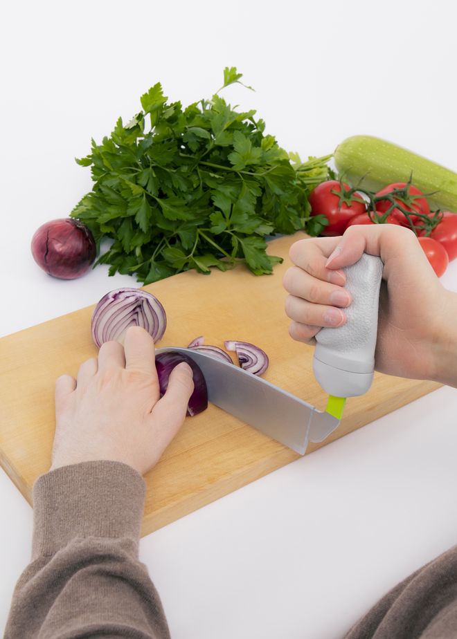 Eine Person mit Cook Ability Griff und Messeraufsatz zerschneidet Zwiebeln