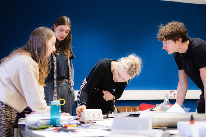 mehrere Personen arbeiten stehend gemeinsam an ihren Projekten