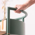 One hand holds onto the handle of the side table.