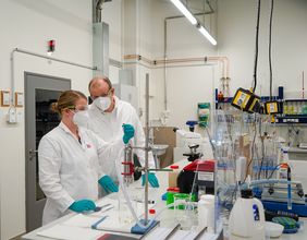 Prof. Dr. Silvio Beier examines wastewater samples in the laboratory with an employee of the Chair of Urban Bioengineering for Resource Recovery. (Photo: Dana Höftmann)