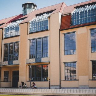 Hauptgebäude der Bauhaus-Universität Weimar, davor Fahrradfahrer