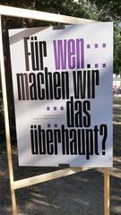 Das Foto zeigt eines der Wendeplakate von Carmen Draxler. Die provokante Aufschrift lautet: »Für wen machen wir das überhaupt?«. Kleingedruckt ist zu lesen: »Sprache retuschiert. Kenne die Macht deiner Worte!«