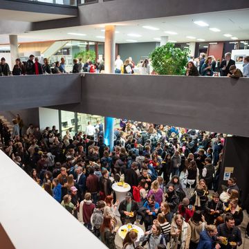 junge Menschen stehen im Foyer der Universitätsbibliothek, es herrscht eine ausgelassene Stimmung