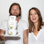 Fotografie von Laura Straßer und Kai Meinig, die lachend das von ihnen gestaltete Geschirr in den Händen halten.