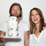 Fotografie von Laura Straßer und Kai Meinig, die lachend das von ihnen gestaltete Geschirr in den Händen halten.